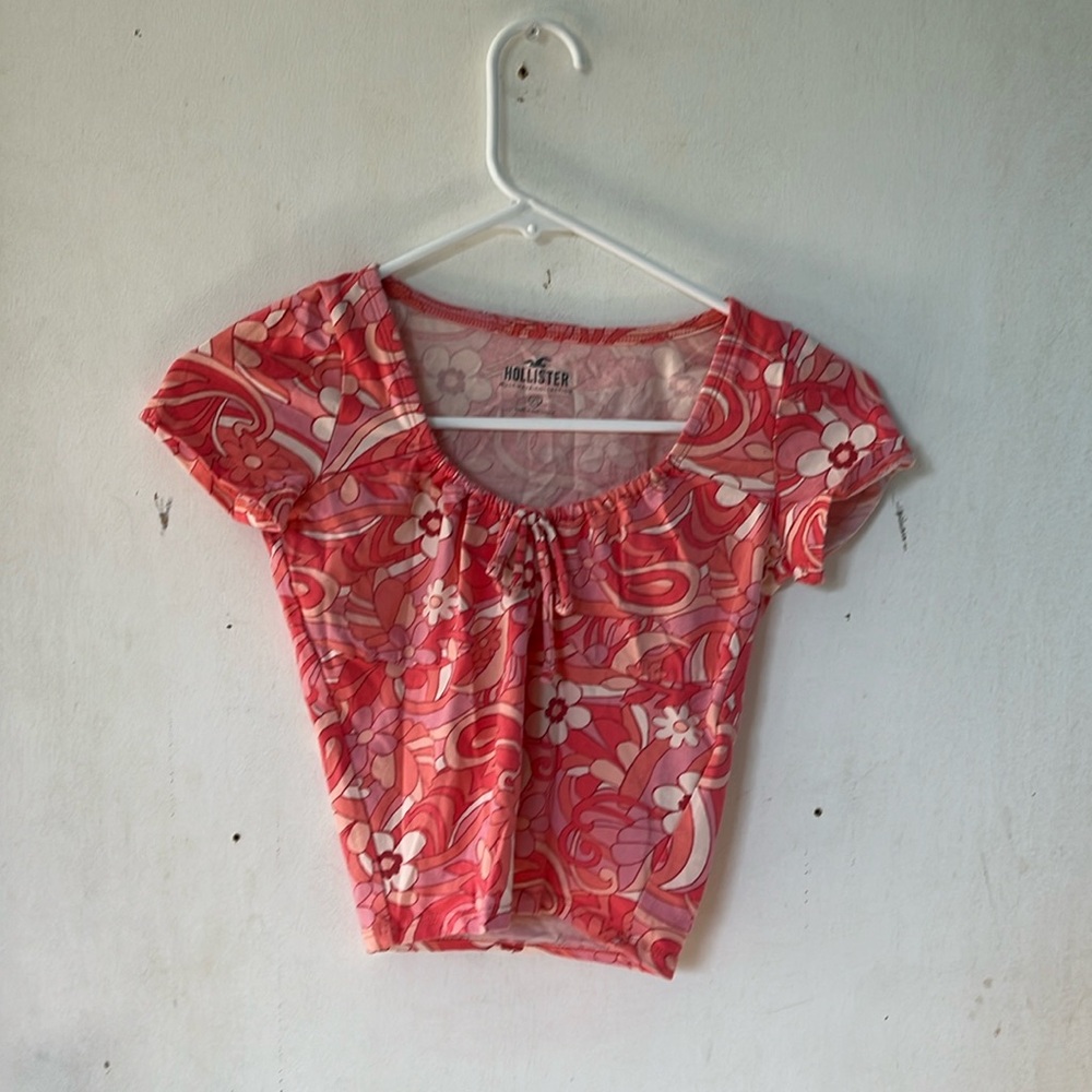 A pink and white flower pattern with a bow that tightens the U neck.